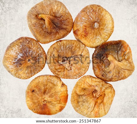 Dried fig fruits. Paper texture. Aged textured photo in retro style