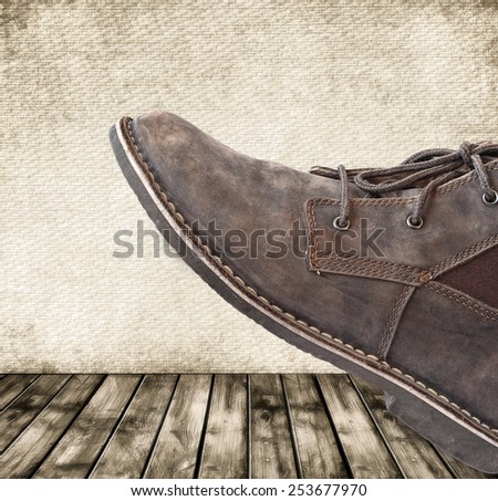 Boot steps closeup on the grunge style wood texture background