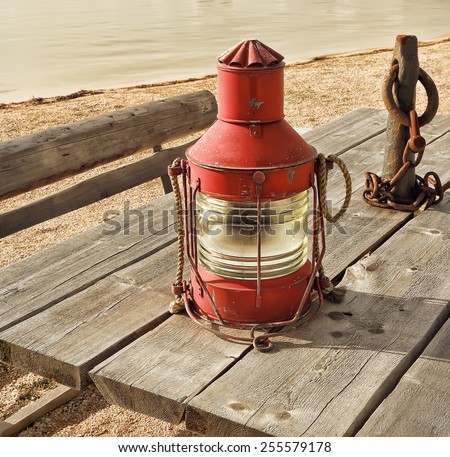 Old fishing lamp on the shore. Vintage effect style pictures