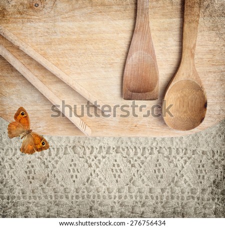 Different wood kitchen tools on the  old wood kitchen cutting board with canvas lace and old textured paper background