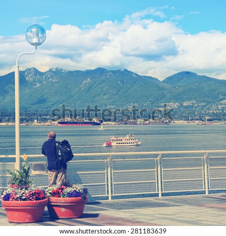 View on Vancouver bay and a tourist looking at. Vancouver, British Columbia. Canada. Image done in vintage retro instagram style