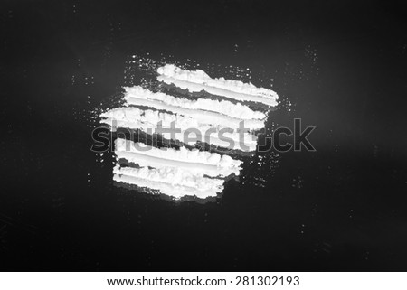 Cocaine powder in lines on a grunge black background
