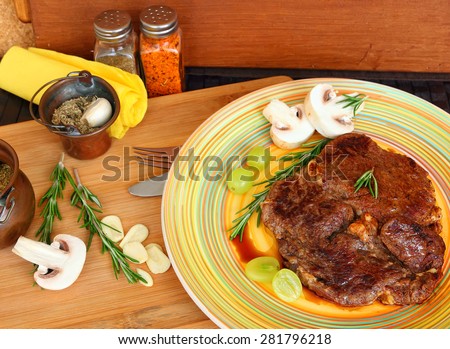 Meat (low fat beef steak) with fresh  mushrooms, herbs and grapes of Mediterranean cuisine. Selective focus