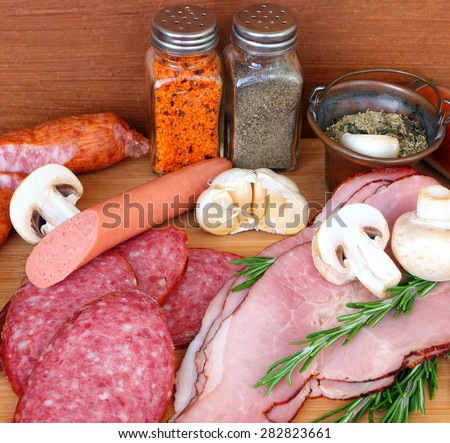 Various delicious low fat meats, salamis and sausages with raw fresh mushrooms and herbs. Mediterranean cuisine.Close up. Selective focus