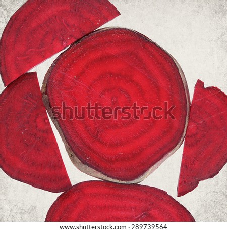 Textured old paper background with natural food - beetroot sliced. Colorful healthy food.