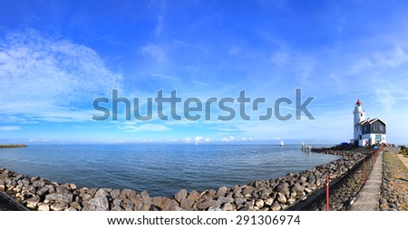 Dutch pastoral nature landscape with a small lighthouse on seacoast. Panoramic view (Marken. Netherlands)