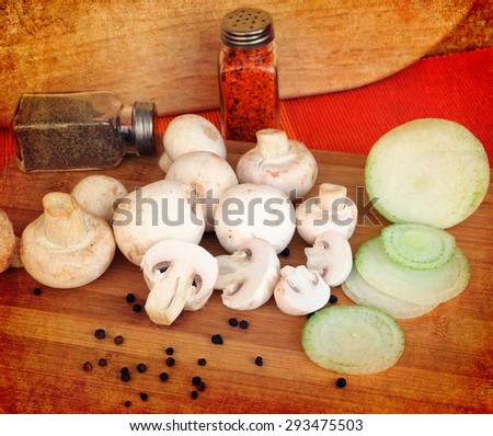 Fresh raw white champions, sliced onion and spices on the kitchen wood table background.Selective focus. Image done on textured old paper background in retro style