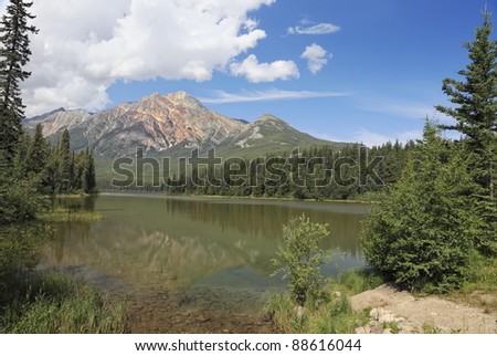 Reflection in smooth water of Pyramid Lake (Jasper National Park, Alberta, Canada)