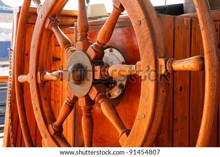 Close up of a steering wheel of the ship made of a wood