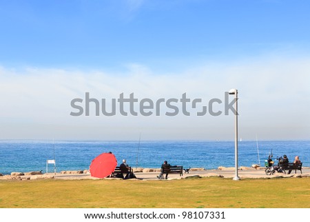 People having a rest and fishing on the quay of Mediterranean sea in the quiet morning and a beautiful sea landscape