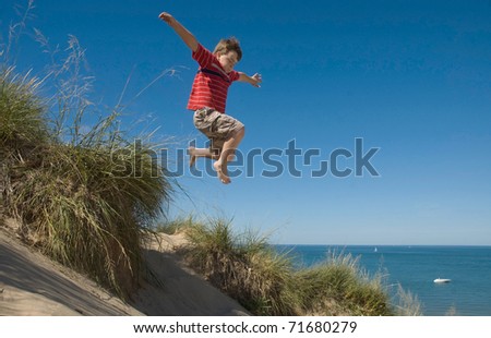Boy jumping off dune