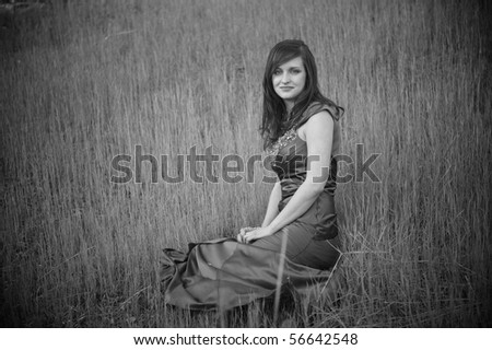 Young pretty brunette wearing prom dress outdoors at sunset