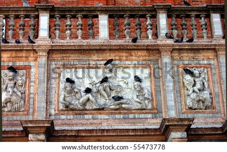 Pigeons rest on a relief in St. Mark\'s Square in Venice, Italy