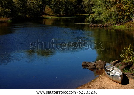 A canoe rests on the shore of the Concord River adjacent to the Old North Bridge in Concord, MA