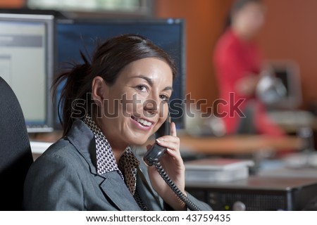 A female office worker talking on the telephone