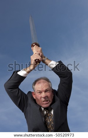 A businessman grimaces as he raises a sword above his head, ready to strike. Vertical shot.