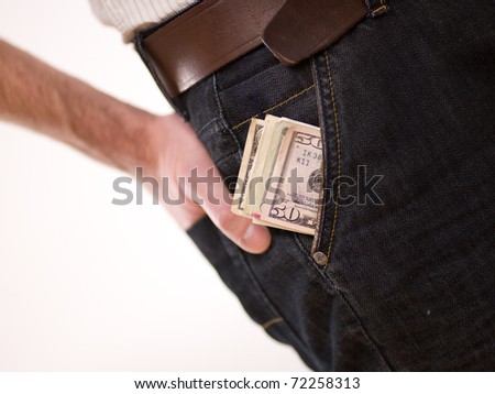A man putting american money in his pants pocket