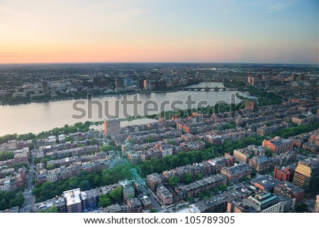 Boston Charles River sunset aerial view with urban buildings and bridge.