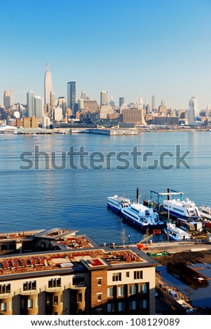 New York City skyline panorama over Hudson river with boat and skyscraper viewed from New Jersey.