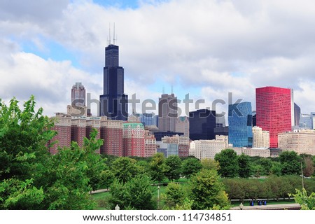 Chicago skyline with trees and law with cloudy blue sky.
