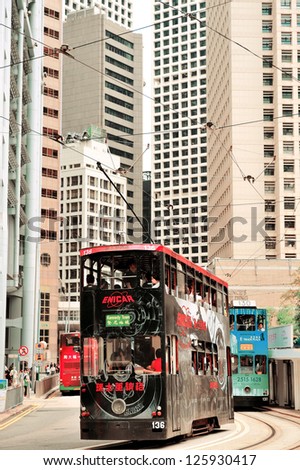 HONG KONG, CHINA - APR 23: Double-deck bus with skyscrapers on April 23, 2012 in Hong Kong, China. The Double-deck trams system in Hong Kong is one of three and the most famous in the world.