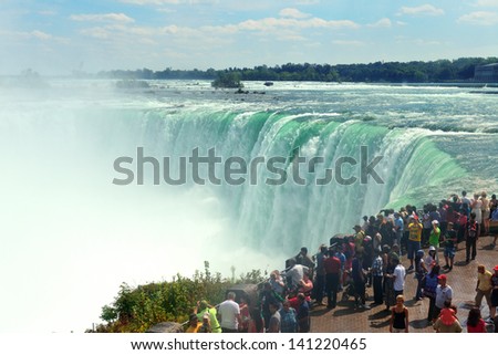 NIAGARA FALLS, NY - SEPT 1: Visitors watch Horseshoe Falls on September 1, 2012 in Niagara Falls, New York. Niagara Falls is the waterfalls with the highest flow rate in the world.