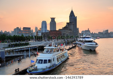 Boat in Huangpu River with Shanghai urban architecture at sunset in dock