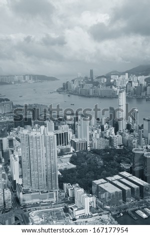 Victoria Harbor aerial view and skyline in Hong Kong with urban skyscrapers in black and white.