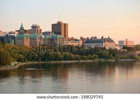 Ottawa sunset over river with historical architecture.