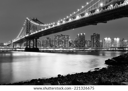 New York City Manhattan Bridge closeup black and white with downtown skyline over East River.