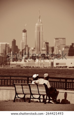 Old couple sit at waterfront with Manhattan city view