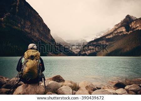 A female hiker at Lake Louise in Banff national park with mountains and forest in Canada.