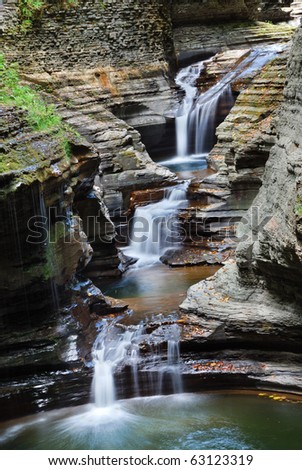 Waterfall in woods with rocks and stream in Watkins Glen state park in New York State
