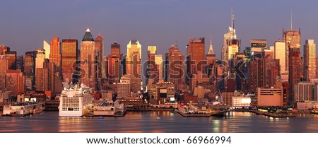 Urban city sunset. New York City Manhattan skyline panorama at sunset with Times Square and skyscrapers with reflection over Hudson river.