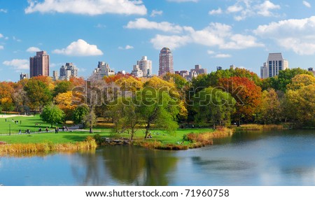 New York City Central Park panorama view in Autumn with Manhattan skyscrapers and colorful trees over lake with reflection.