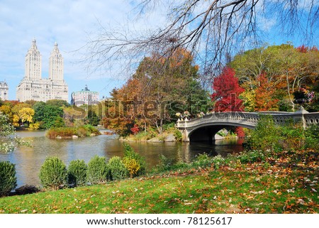 New York City Manhattan Central Park panorama in Autumn lake with bridge skyscrapers and colorful trees with reflection.