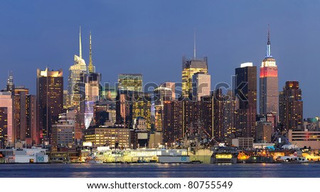 New York City Manhattan midtown skyline panorama at dusk with historical landmark skyscrapers over Hudson River viewed from New Jersey Weehawken waterfront.