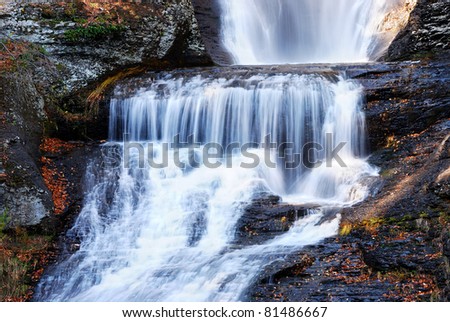 Waterfall in Autumn mountain with woods, foliage and rocks. From Digmans Fall of Pennsylvania