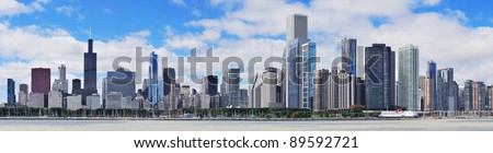 Chicago city urban skyline panorama with skyscrapers over Lake Michigan with cloudy blue sky.