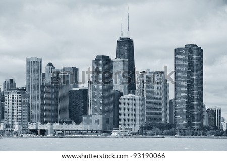 Chicago city urban skyline black and white with skyscrapers over Lake Michigan with cloudy blue sky.