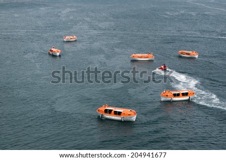 Orange and white lifeboats training and testing for safety requirements