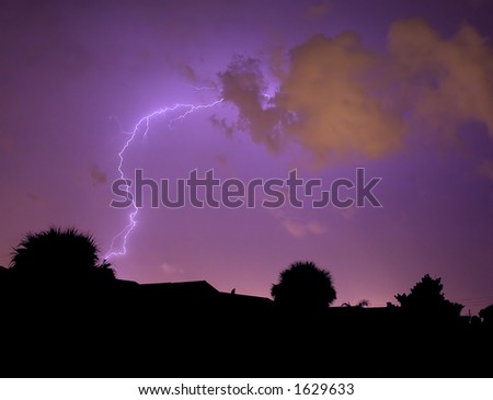 Wild lightning strike with street light reflection on clouds