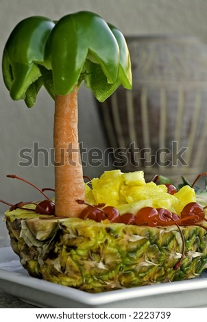 A carved Pineapple boat with cherries and pineapple chunks