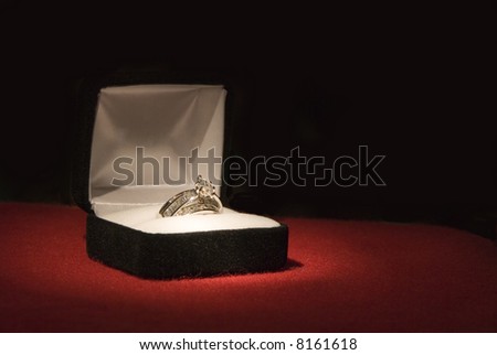 stock photo A beautiful 2 carat wedding ring on red felt with black 