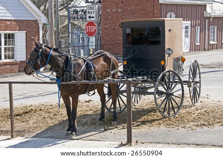 Amish horse and buggy hitched to a post in a modern community