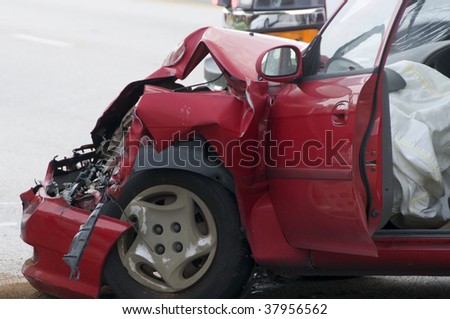 Red vehicle with smashed front end showing air bag deployment