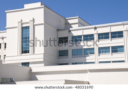 Exterior of hospital with tinted windows and blue sky