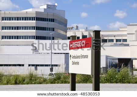 Bright red hospital Emergency entrance sign in front of a hospital building