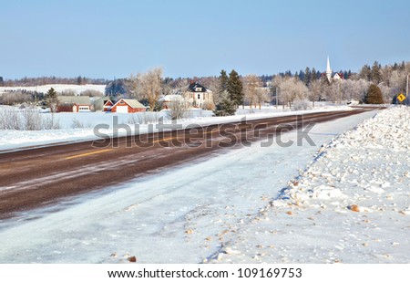 Winter road running through farmland in rural Prince Edward Island, Canada.