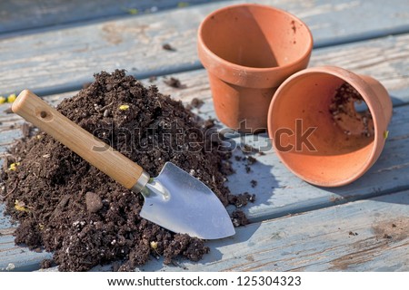 Soil and trowel to fill two empty clay pots.